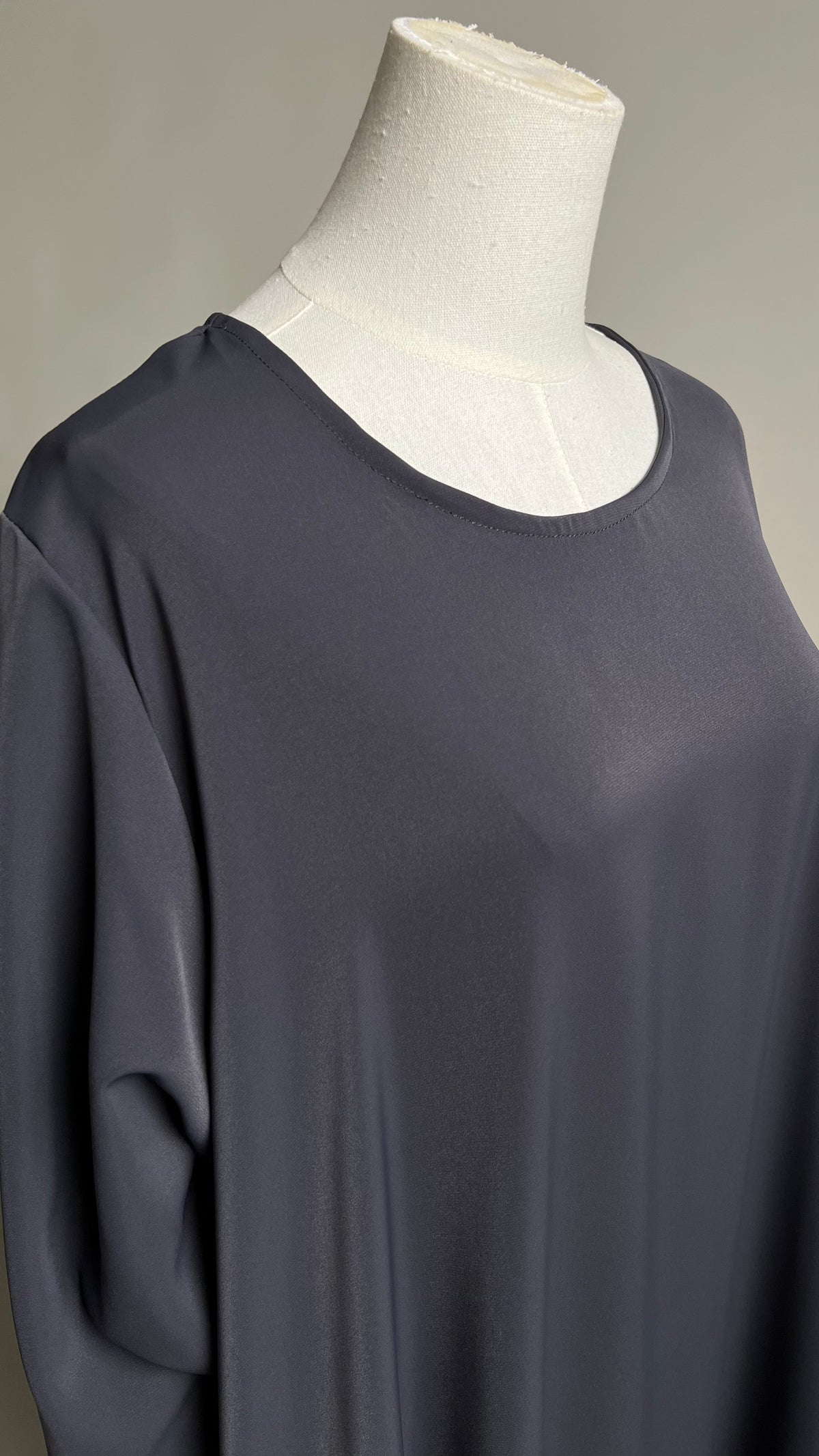 Close-up of the round neckline on the dark grey Safiyyah Closed Abaya