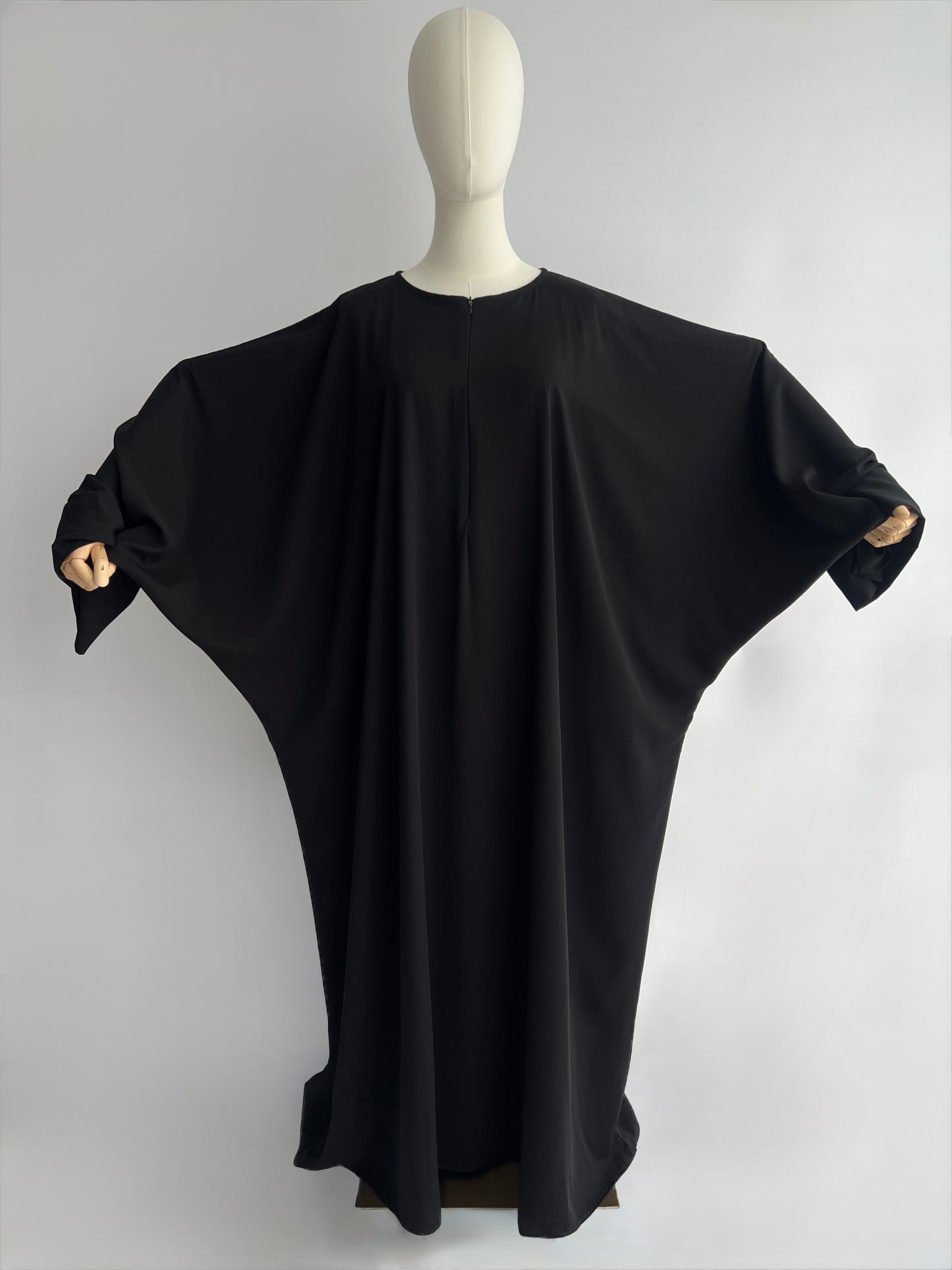 Essential Zip Abaya width demonstration, front view showing fabric span