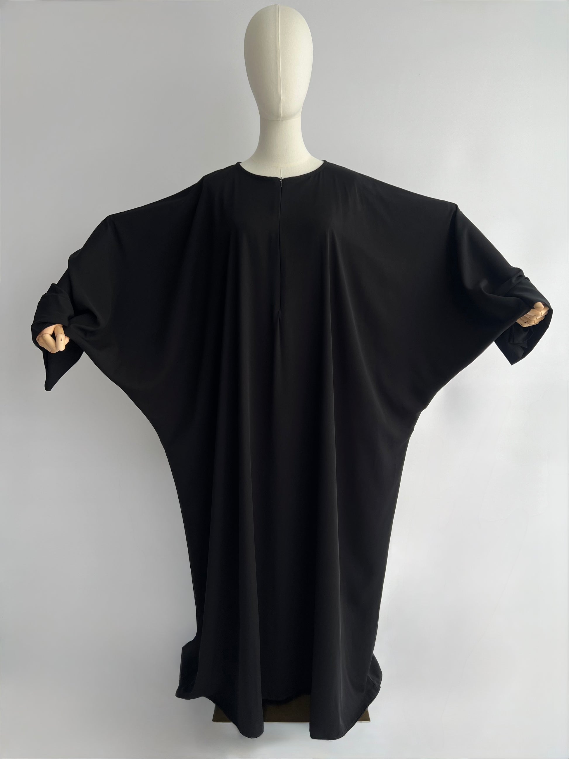 Essential Zip Abaya width demonstration, front view showing fabric span